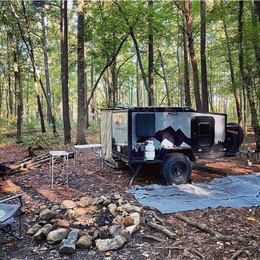 Teardrop camper and the nature background: woods and a campfire spot | Boreas Campers Homepage